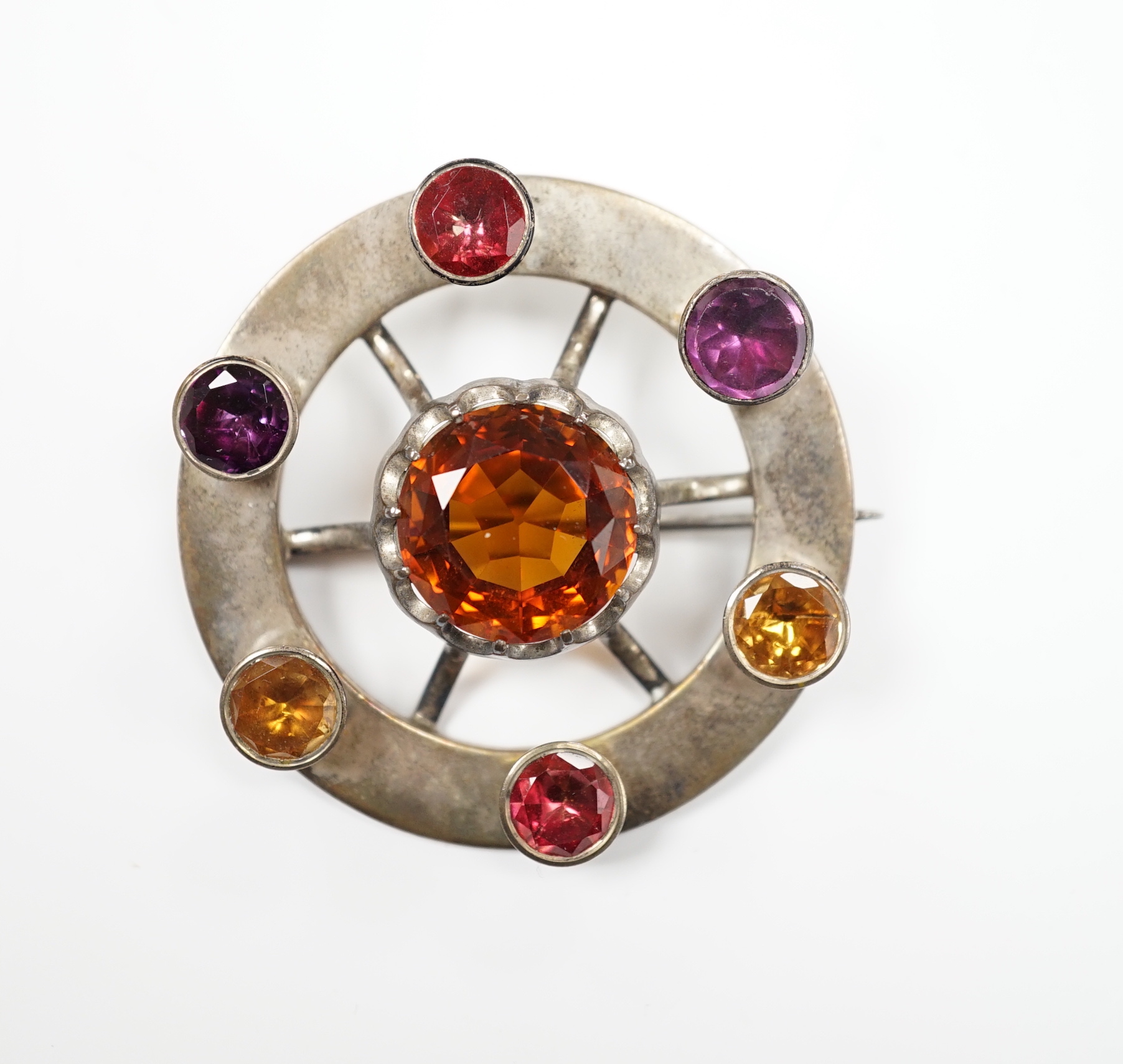 A white metal and multi gem set openwork circular brooch, with central dark citrine, diameter 49mm.